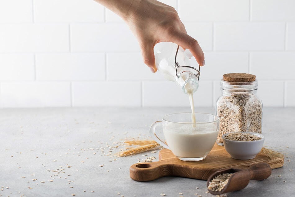 a woman pours oat milk into a mug alternative mil 2025 02 12 12 50 45 utc